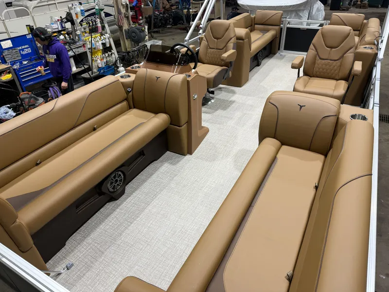 Slide: The Image of The image shows the interior of a Tahoe Sport 2380 Quad Lounge boat with brown leather seating and a central helm. - 28