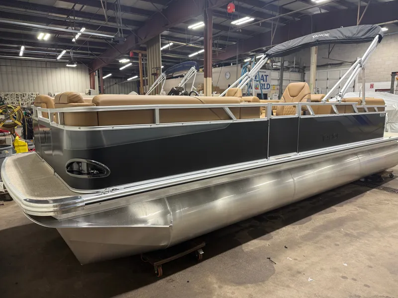 Slide: The Image of A modern pontoon boat with beige seating and a black canopy in a warehouse setting. - 32