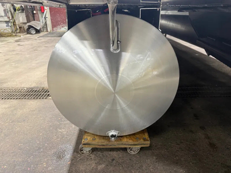 Slide: The Image of Close-up of a shiny, round metal part on a wooden board in a workshop. - 36