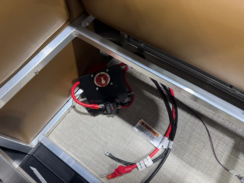 Slide: The Image of A battery disconnect switch with red cables in a boat storage compartment. - 43