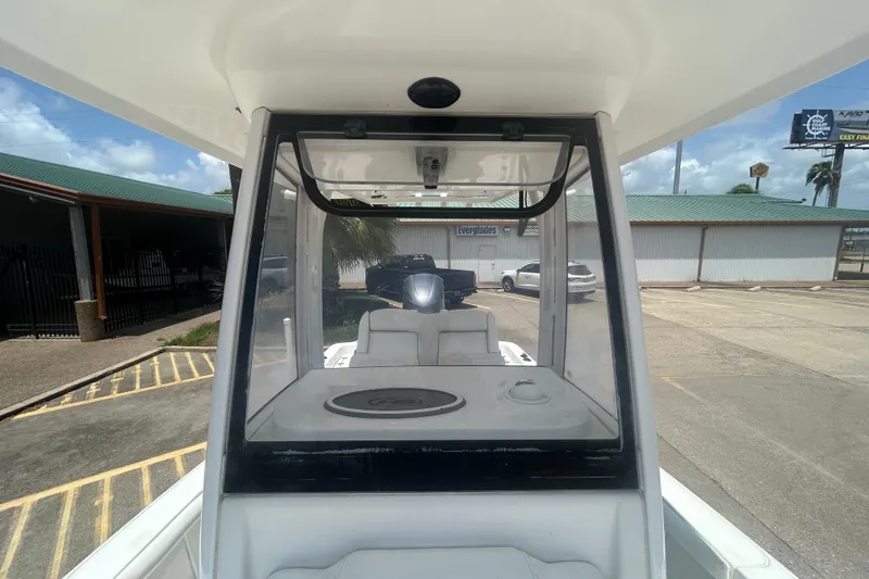 Slide: The Image of 2018 Sea Hunt BX25FS boat interior with console and seating, parked outdoors. - 14