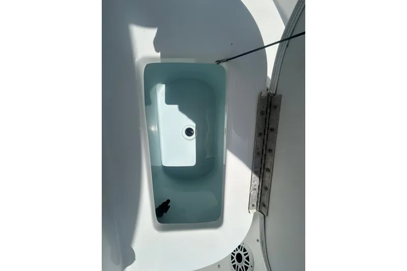 Slide: The Image of Livewell compartment on a 2018 Sea Hunt BX25FS boat, featuring a drain and hinge. - 21