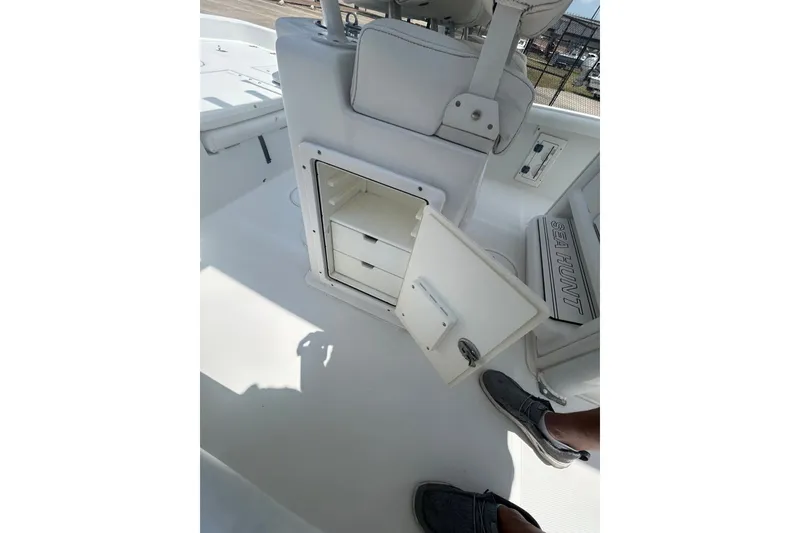 Slide: The Image of 2018 Sea Hunt BX25FS boat interior with open storage compartment and visible seating. - 17