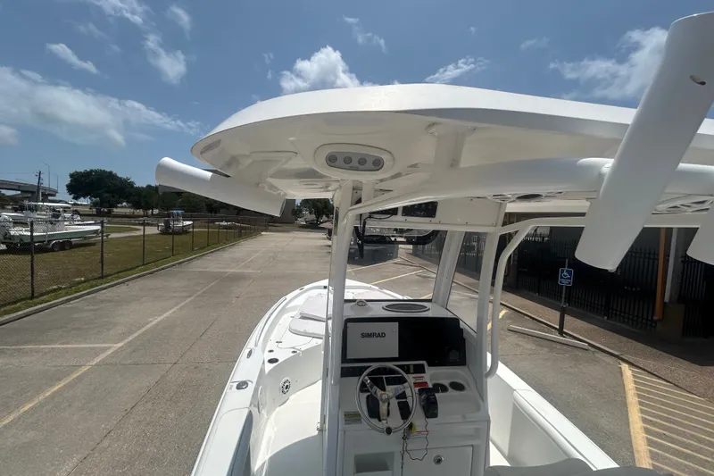 Slide: The Image of 2018 Sea Hunt BX25FS boat with center console and T-top, parked outdoors. - 16