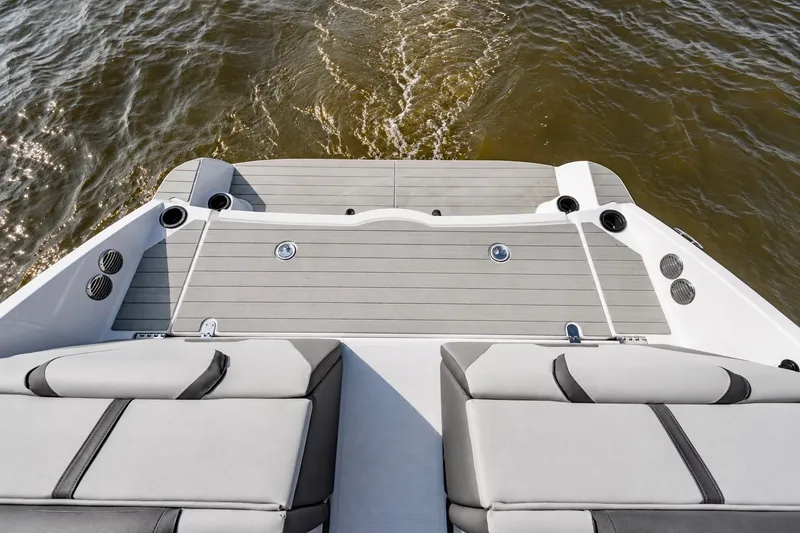 Slide: The Image of 2025 Yamaha Boats AR220 swim platform with cushioned seating and water view. - 14