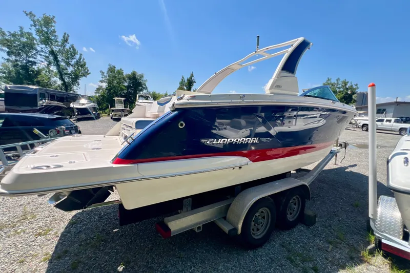 Slide: The Image of 2020 Chaparral 277 SSX boat on trailer, blue and white design, parked outdoors. - 5