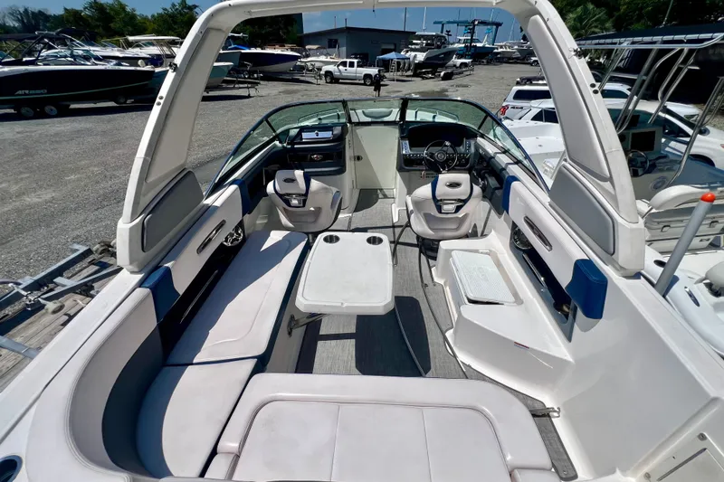 Slide: The Image of 2020 Chaparral 277 SSX boat interior with seating and helm, docked outdoors. - 10
