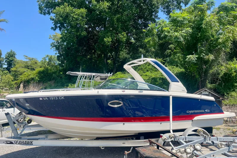 The Image of 2020 Chaparral 277 SSX boat on trailer, surrounded by lush greenery. - 1