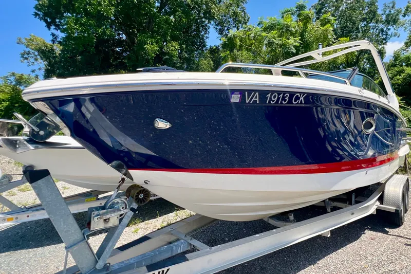 Slide: The Image of 2020 Chaparral 277 SSX boat on trailer, blue and white with red stripe, outdoors. - 2