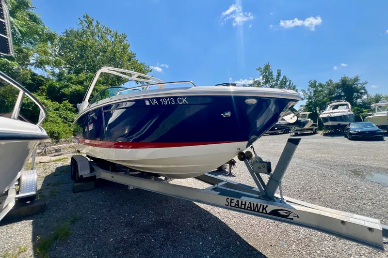 Slide: The Image of 2020 Chaparral 277 SSX boat on trailer, parked outdoors under a clear blue sky. - 4