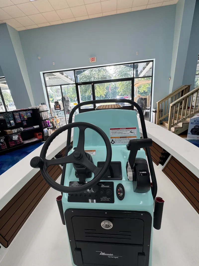 Slide: The Image of The image shows the helm of a 2027 Maverick 18 HPX-V boat in a showroom. - 21
