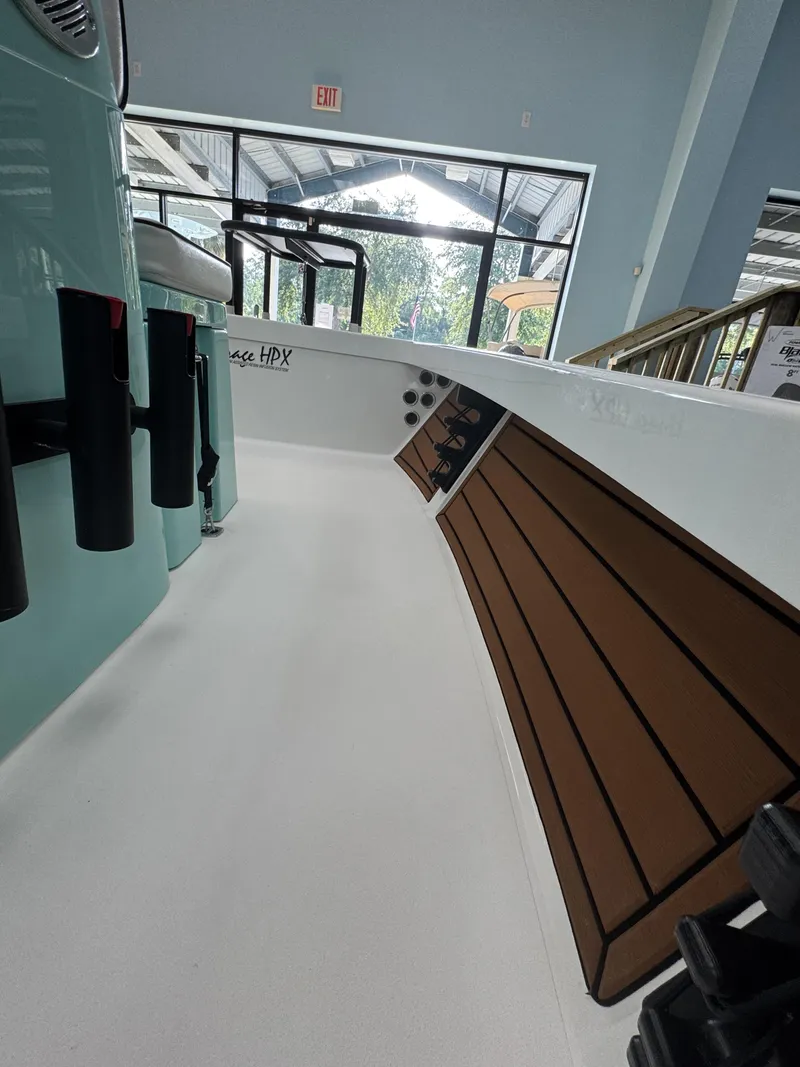 Slide: The Image of The image shows the interior of a 2027 Maverick 18 HPX-V boat. It features a clean, white surface with brown accents on the side. - 23
