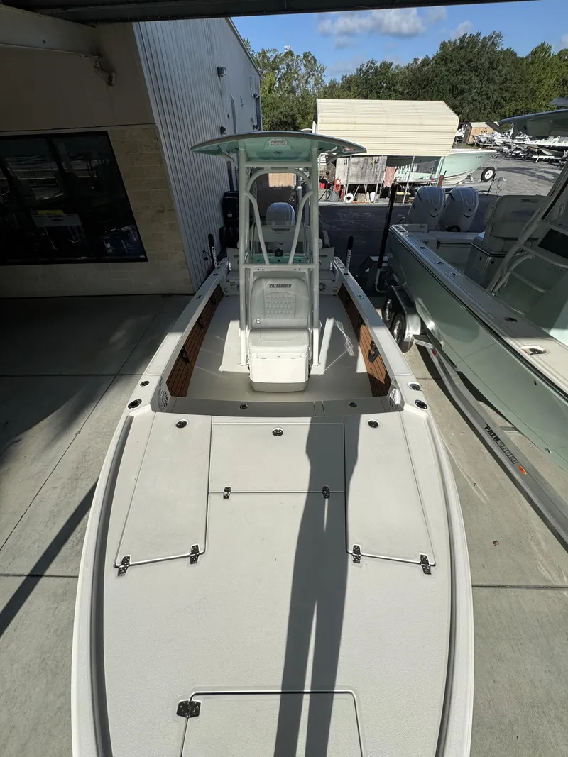 Slide: The Image of A modern fishing boat with T-top, spacious deck, and helm console, parked in a marina area. - 17