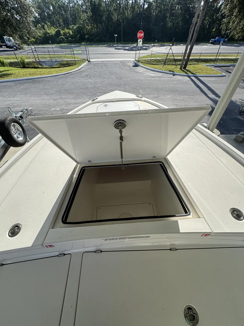 Slide: The Image of An open storage compartment on a Pathfinder 2500 Tournament boat, parked in a lot. - 21