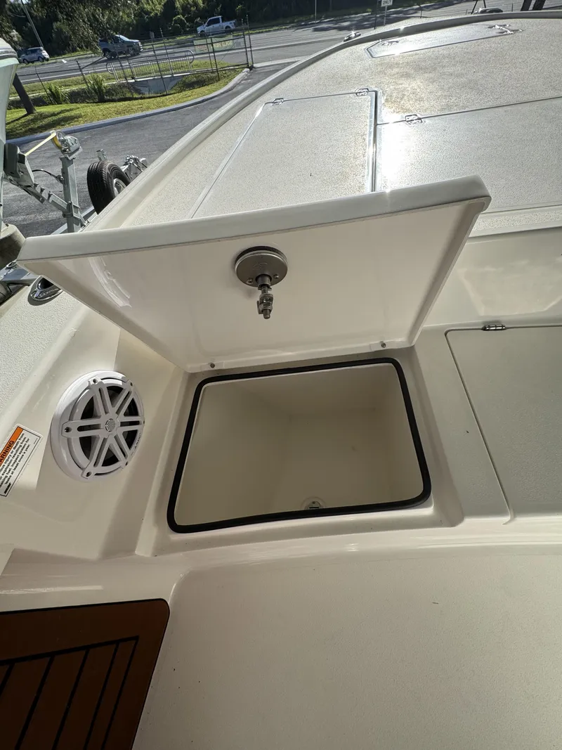 Slide: The Image of An open storage compartment on a 2027 Pathfinder 2500 Tournament boat, with a speaker beside it. - 18