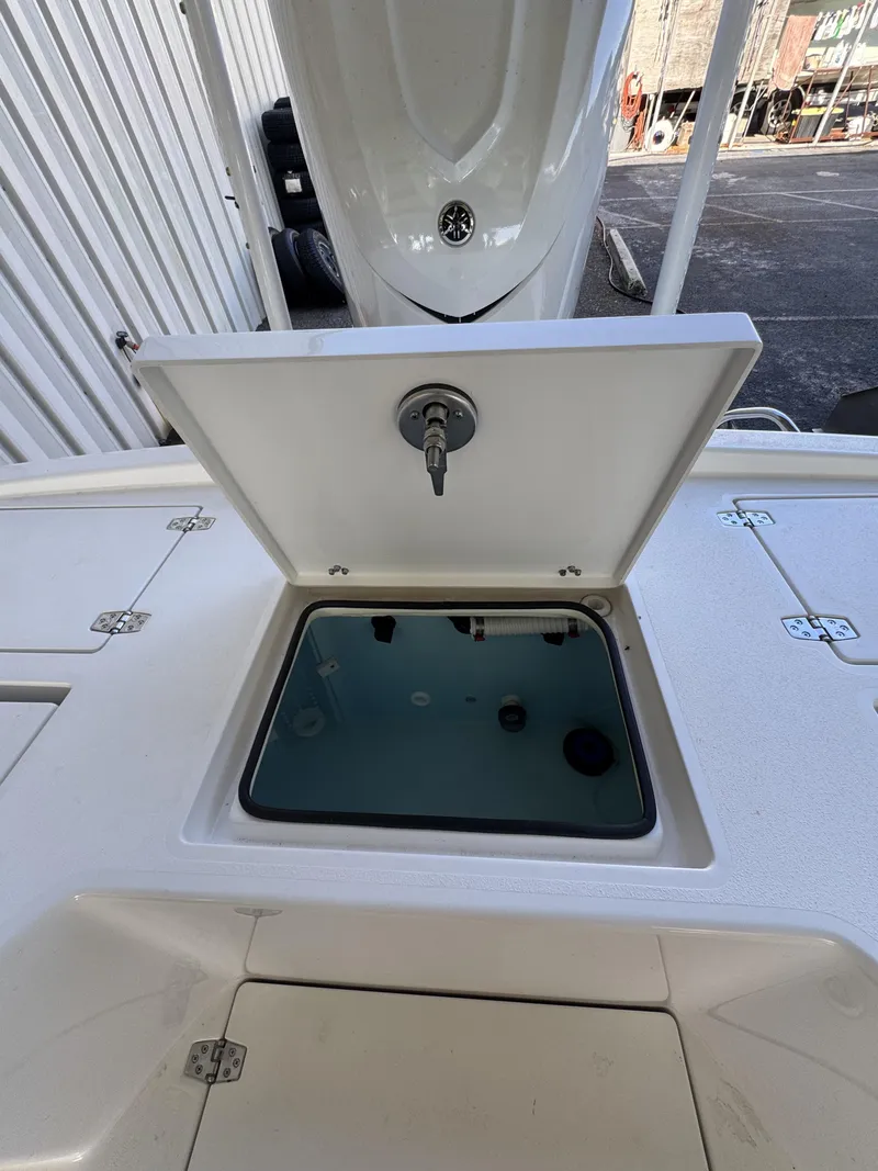 Slide: The Image of An open storage compartment on a 2027 Pathfinder 2500 Tournament boat, featuring a water connection. - 44