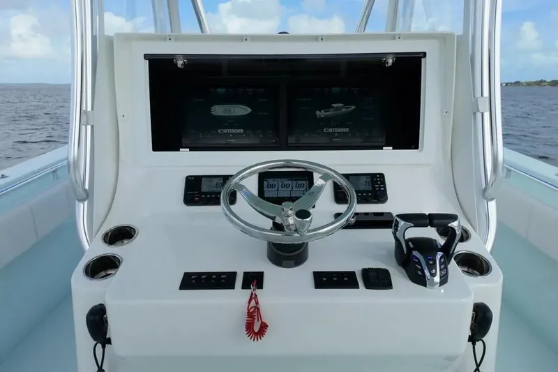 Slide: The Image of 2025 Contender 39 ST boat dashboard with steering wheel and electronic controls. - 15
