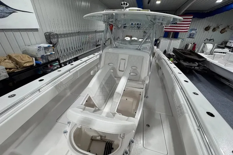 Slide: The Image of 2024 Contender 44 ST boat interior with white seating and fishing equipment in a showroom. - 26