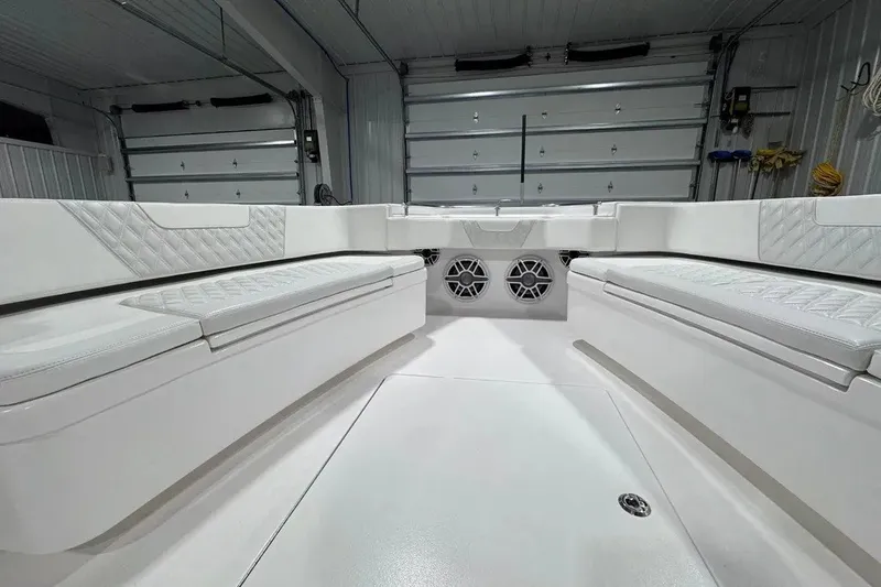 Slide: The Image of 2024 Contender 44 ST boat interior with white cushioned seating and built-in speakers. - 25