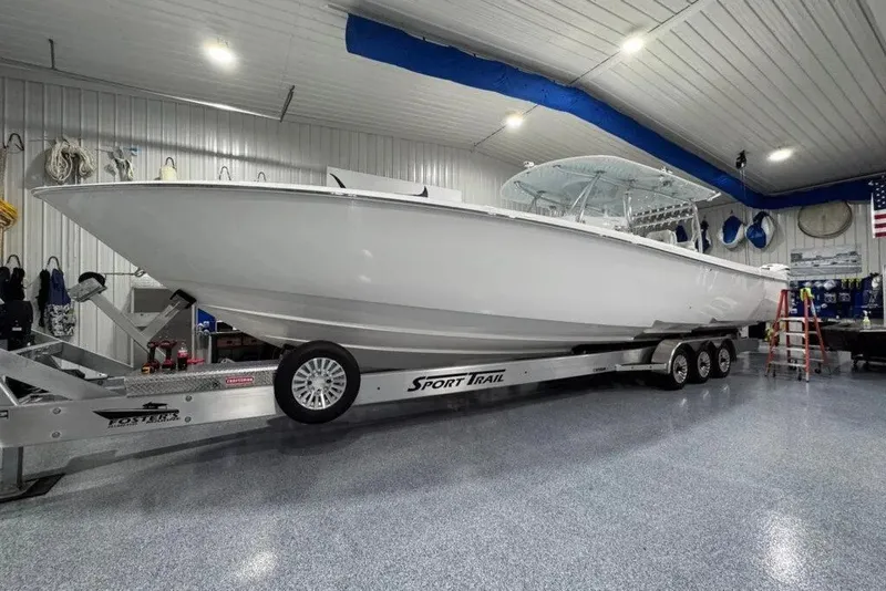The Image of 2024 Contender 44 ST boat on trailer in a spacious indoor garage. - 1