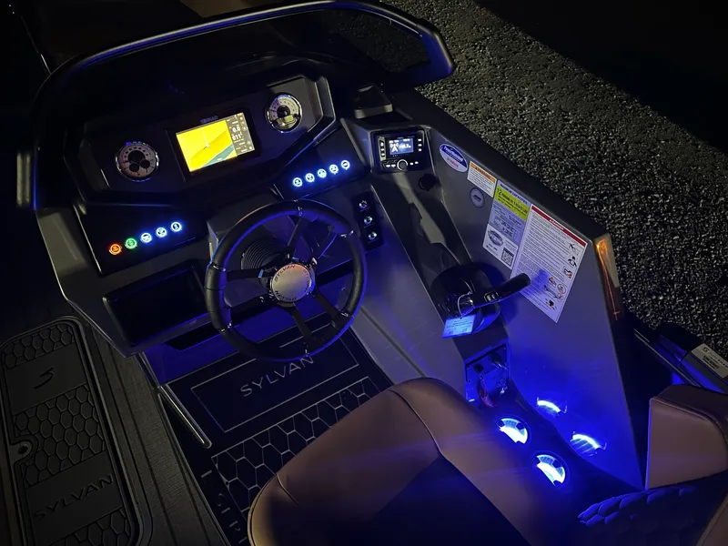 Slide: The Image of The image shows the cockpit of a Sylvan L3 RLZ boat with illuminated instruments and a modern steering wheel. - 2