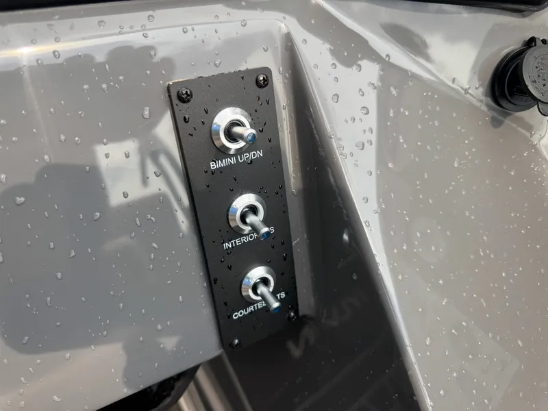 Slide: The Image of Close-up of a control panel with three toggle switches for Bimini, interior, and cockpit lights. - 33