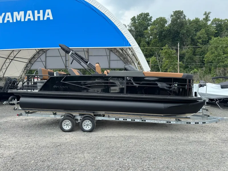 Slide: The Image of A black 2026 Sylvan L3 RLZ pontoon boat on a trailer, parked in front of a blue tent. - 38