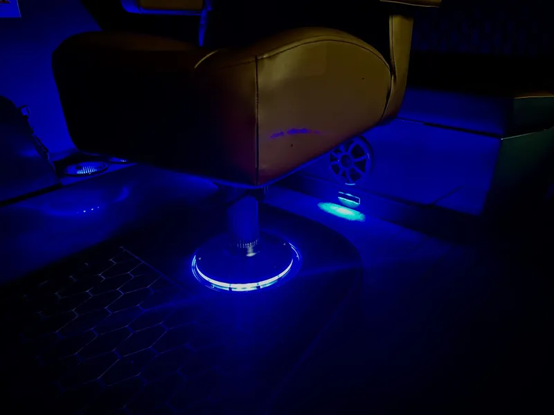 Slide: The Image of A modern boat seat with blue LED lighting underneath, in a dark interior setting. - 14