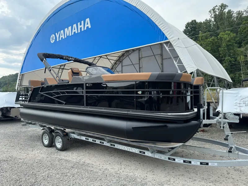 The Image of A 2026 Sylvan L3 RLZ pontoon boat on a trailer in front of a large blue tent. - 1
