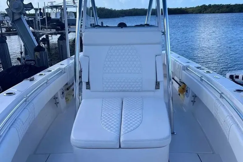 Slide: The Image of 2024 Contender 30 Tournament boat with white seating, docked by the water. - 16