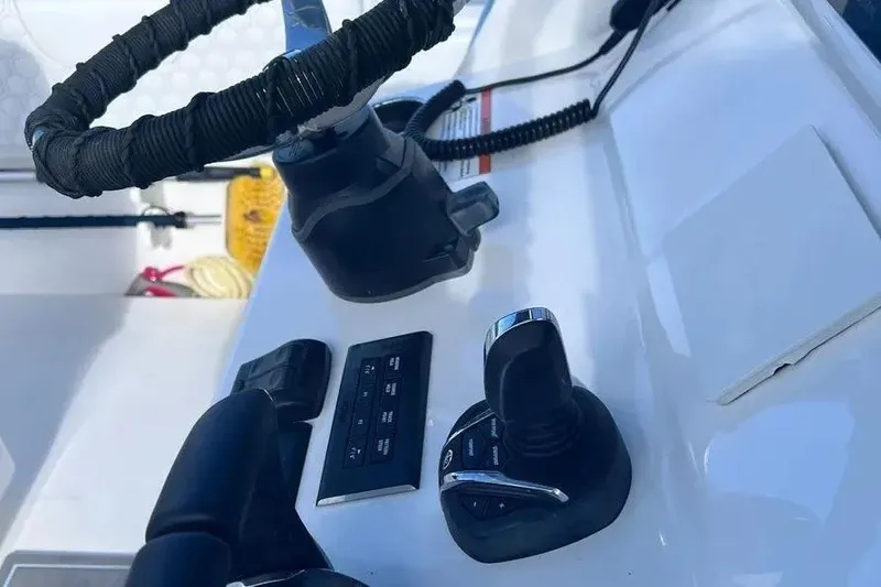 Slide: The Image of 2024 Contender 30 Tournament boat controls with steering wheel and throttle. - 10