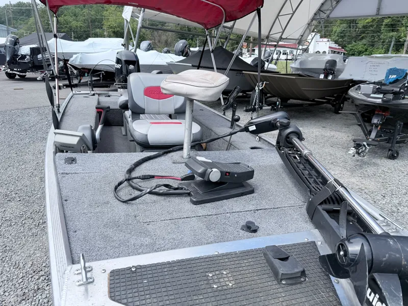 Slide: The Image of A 2016 Tracker Panfish 16 with gray carpet flooring and red sunshade. It features a helm and seating. - 15