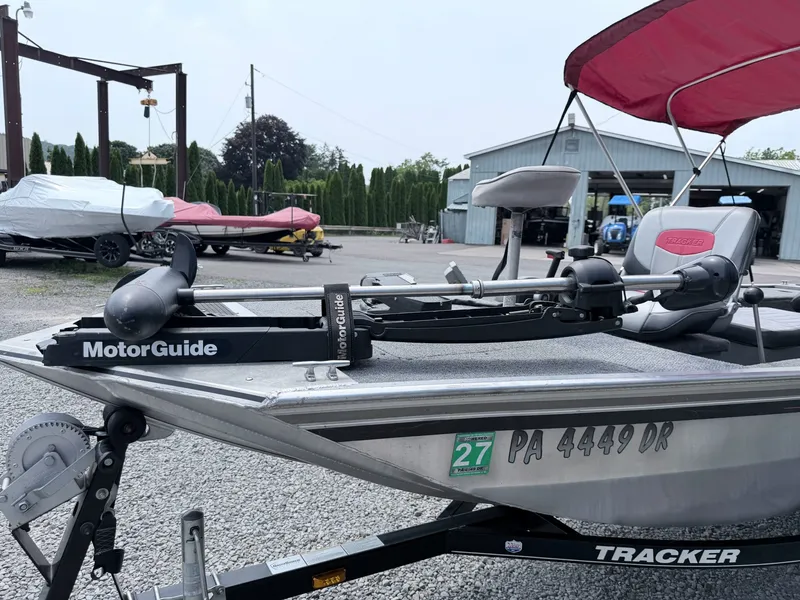 Slide: The Image of A 2016 Tracker Panfish 16 with a MotorGuide motor, parked on a trailer in a yard. - 22