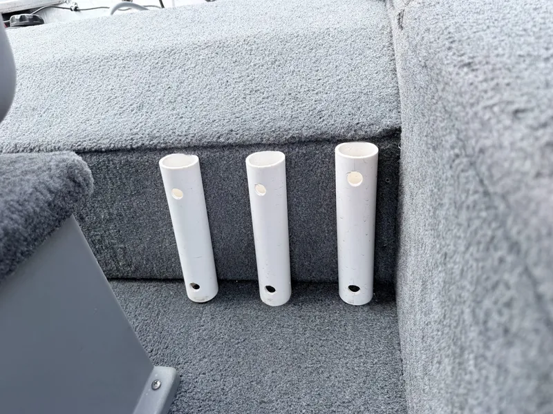 Slide: The Image of Three white rod holders are integrated into the gray carpeted floor of a boat. - 18
