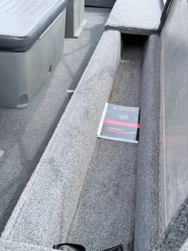 Slide: The Image of The image shows the interior of a 2016 Tracker Panfish 16 boat with gray carpeting. - 21