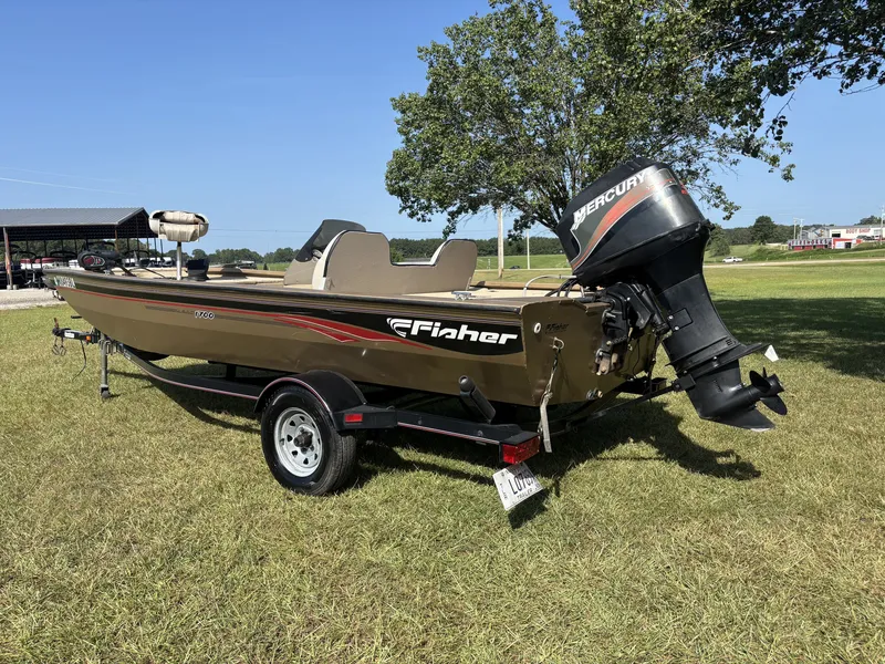 Slide: The Image of A 2006 Fisher 1700 boat on a trailer in a grassy area, featuring a Mercury engine. - 7