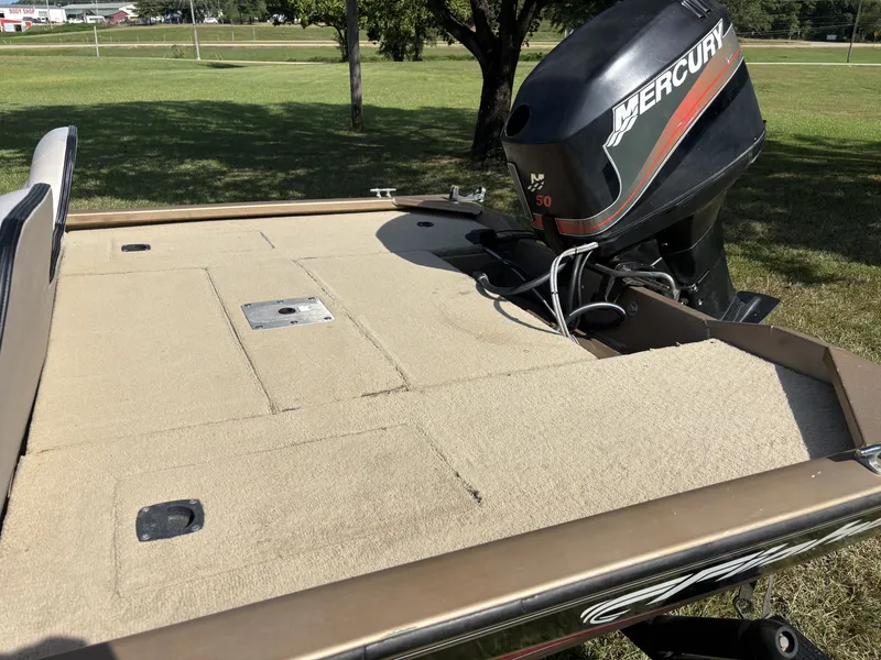 Slide: The Image of A 2006 Fisher boat with a Mercury outboard motor, parked on grassy terrain. - 4