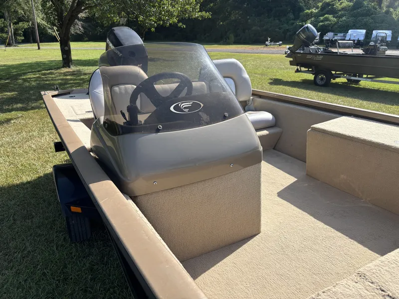 Slide: The Image of A 2006 Fisher Boats 1700 with a simple helm and beige seating on a trailer. - 14