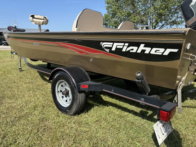 Slide: The Image of A 2006 Fisher Boats 1700 on a trailer, parked on grass. - 2
