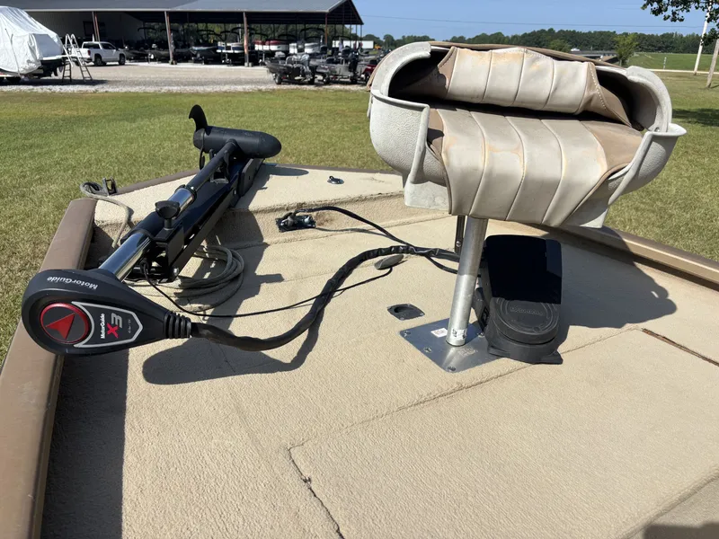 Slide: The Image of A fishing boat with a seat and trolling motor on the deck, surrounded by green grass. - 8
