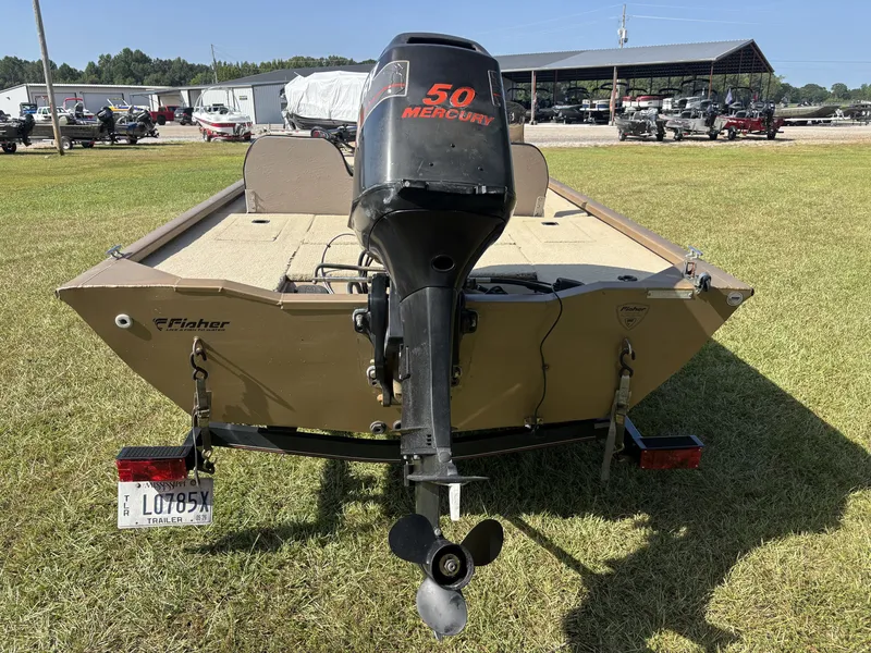 Slide: The Image of A 2006 Fisher Boats 1700 with a 50 HP Mercury outboard motor, on a trailer on grass. - 13