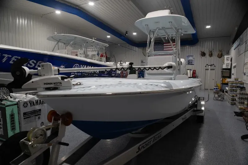 The Image of 2024 Contender 26 Bay boat in showroom, featuring Minn Kota trolling motor. - 1