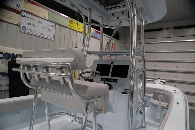 Slide: The Image of 2024 Contender 26 Bay boat interior with helm and seating in a showroom. - 15