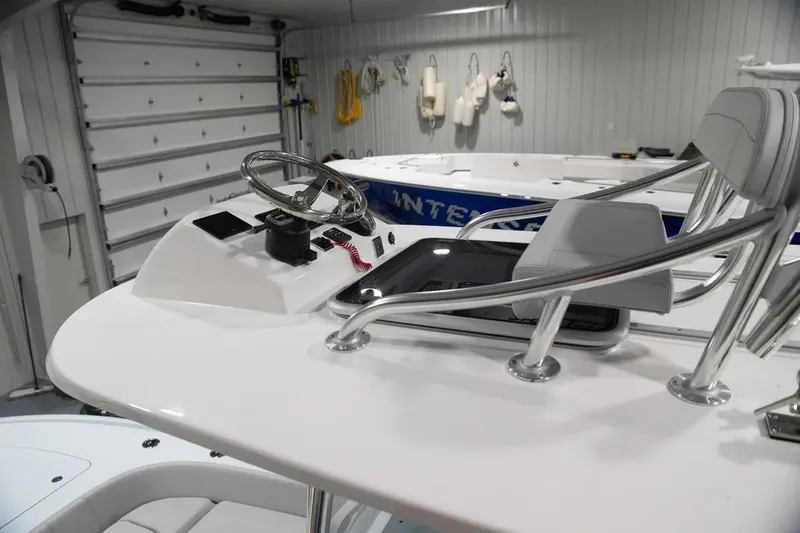 Slide: The Image of 2024 Contender 26 Bay boat helm with steering wheel and controls in a garage setting. - 17