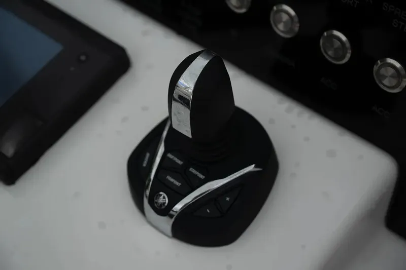 Slide: The Image of Joystick control on 2023 Contender 44 ST boat dashboard, featuring sleek design and buttons. - 18