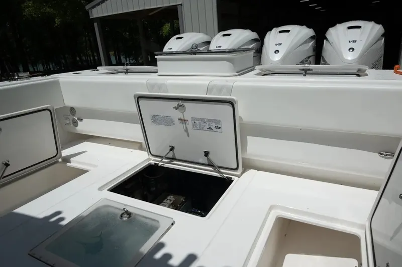Slide: The Image of 2023 Contender 44 ST boat deck with open storage compartments and V8 engines. - 7