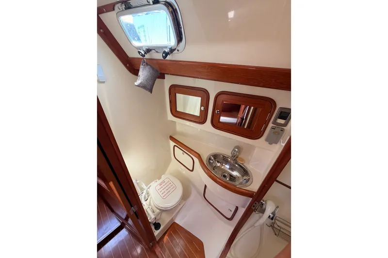 Slide: The Image of Compact bathroom in 2005 Tayana 48 yacht with sink, toilet, and wooden accents. - 59