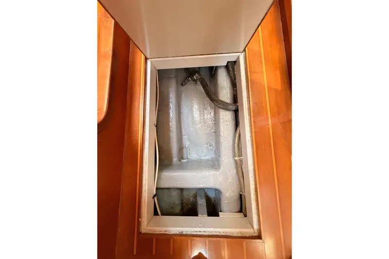 Slide: The Image of Engine compartment of 2005 Tayana 48 sailboat with visible hoses and wooden flooring. - 113