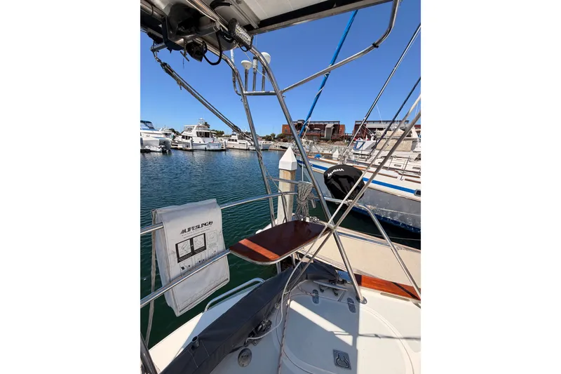 Slide: The Image of Sailboat deck view of 2005 Tayana 48 in marina, featuring lifebuoy and clear blue sky. - 29
