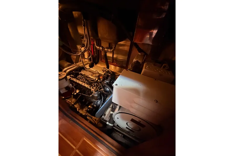 Slide: The Image of Engine room of a 2005 Tayana 48 yacht, showcasing mechanical components and wiring. - 115